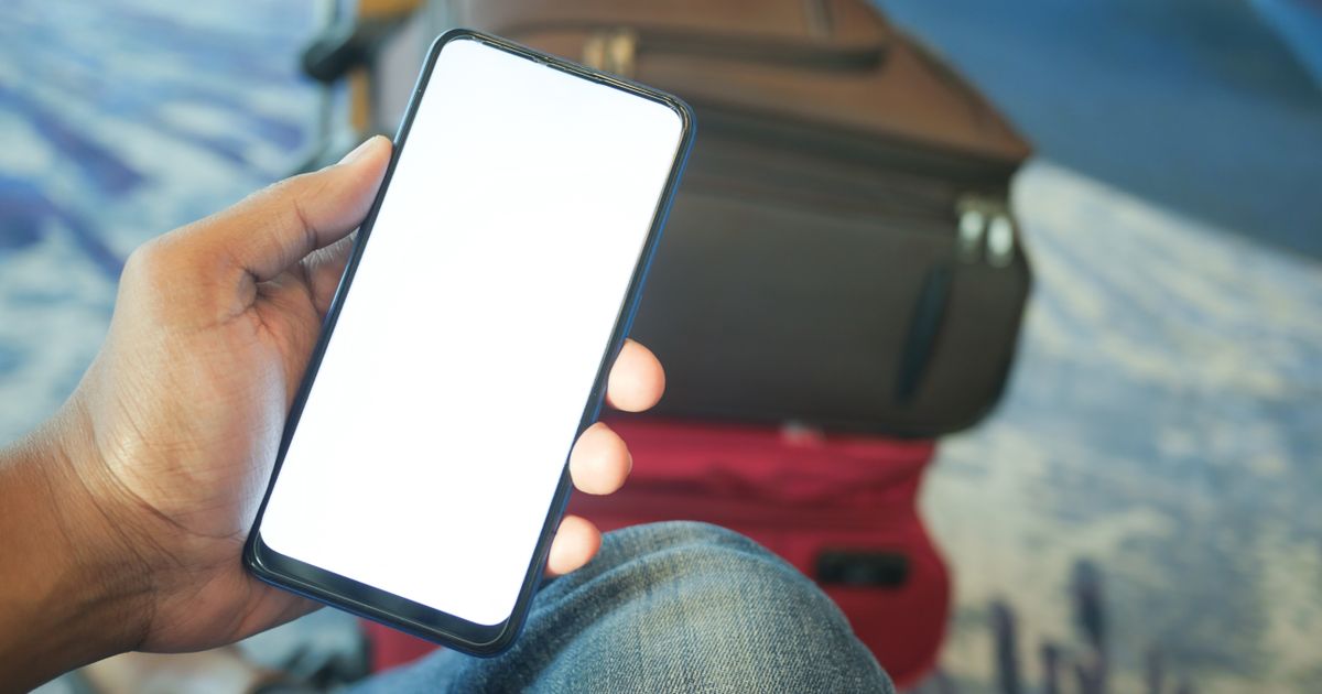 Traveller checking their phone at the airport before a US flight