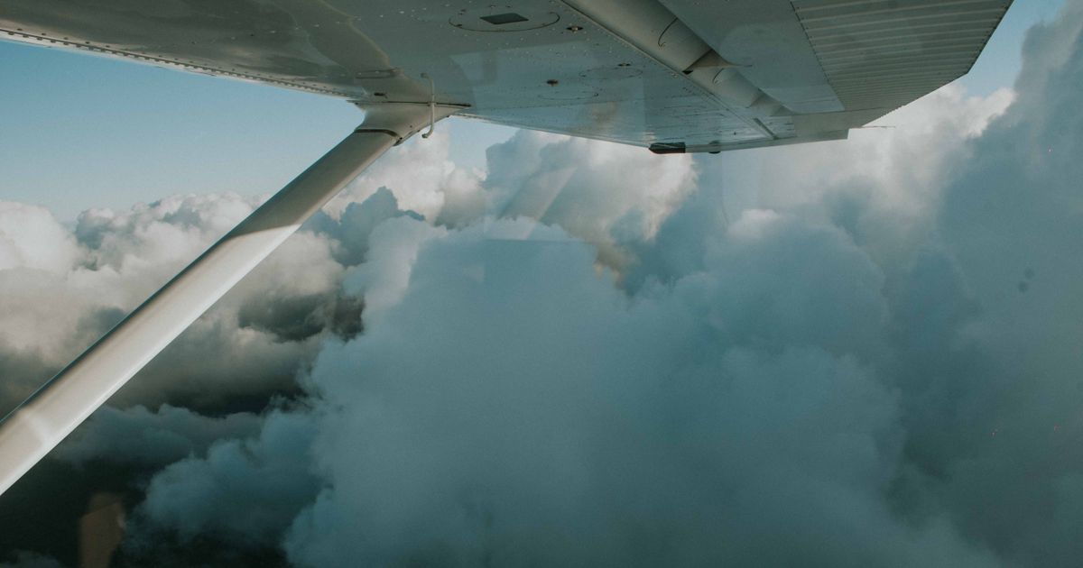 View over the wing of a plane above the clouds on the way to Florida